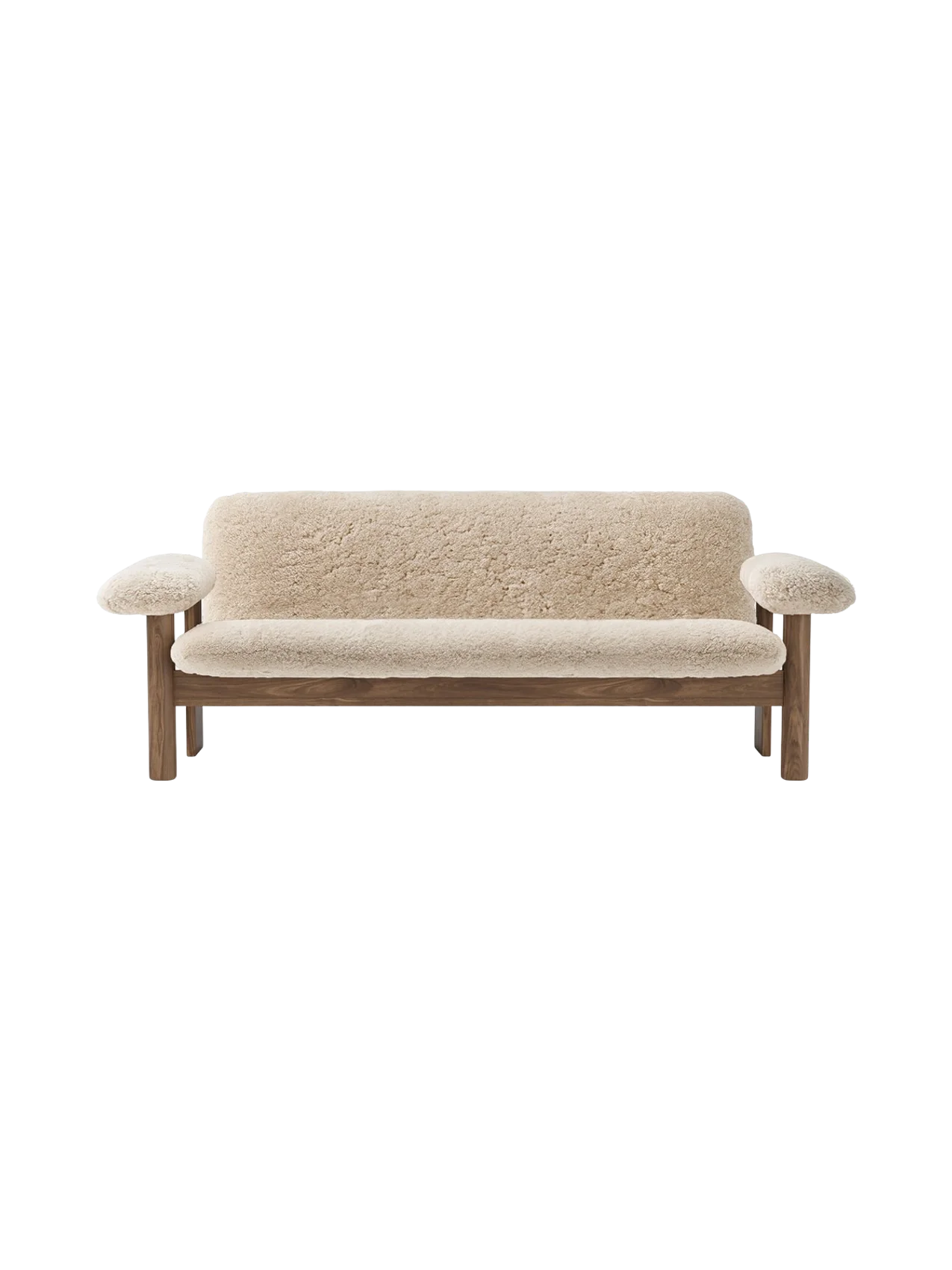 Front view of the Brasilia Sofa with a natural wood frame and off-white sheepskin upholstery against a black background.