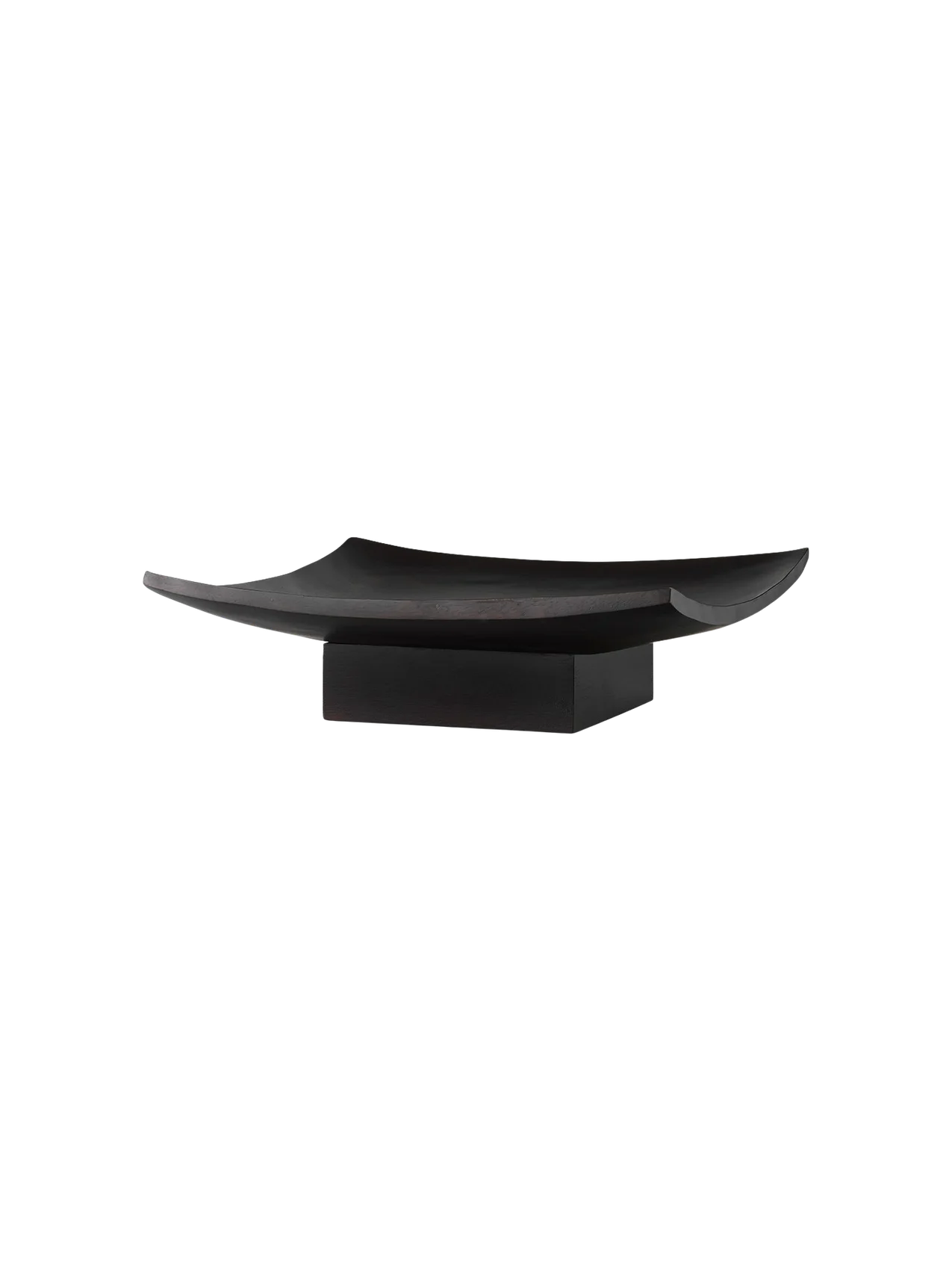 Angled view of the Releve Platter in black wood. The long, sculptural platter has curved, upturned edges and a solid base.