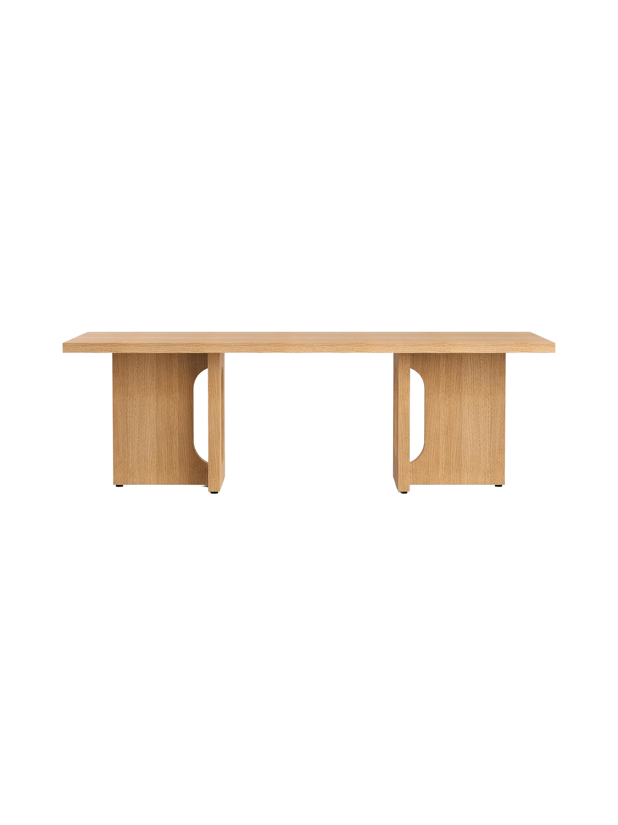 The Androgyne Lounge Table in natural oak. A long, low rectangular table with two solid legs featuring distinctive cutouts.