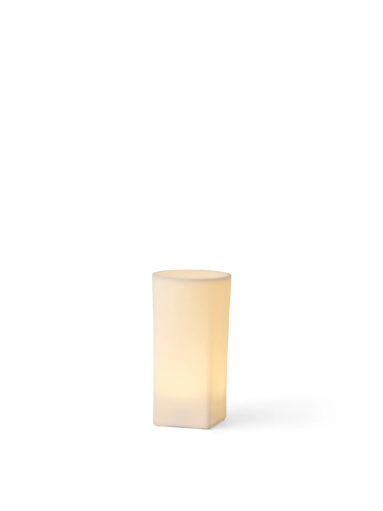 Ignus Flameless Candle, H15 version, turned on. A sculptural, square-based column in off-white bone china, glowing warmly.