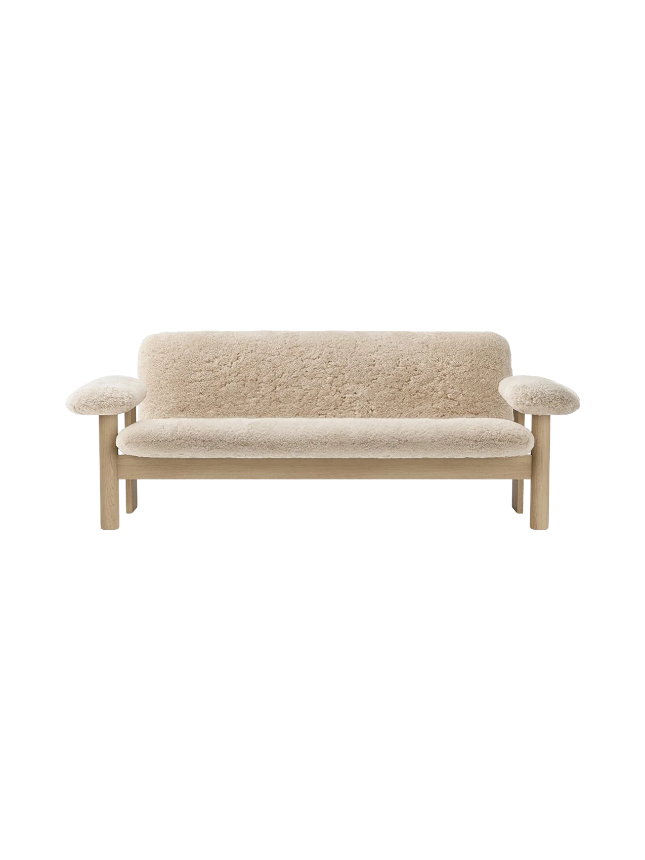 Front view of the Brasilia Sofa upholstered in light-coloured sheepskin, with a solid natural oak frame and rounded armrests.