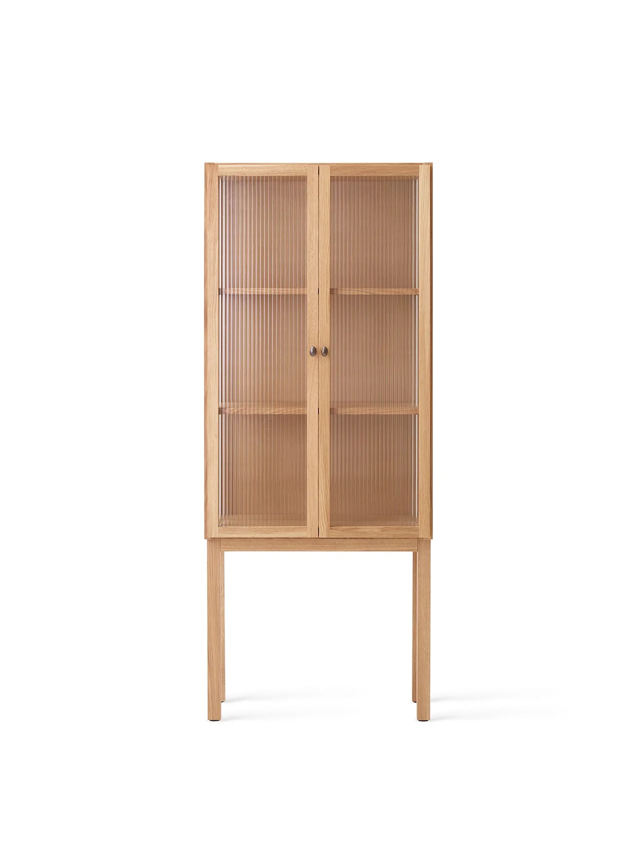 Front view of the tall oak Curiosity Cabinet. The cabinet features two reeded glass doors, revealing two shelves within.