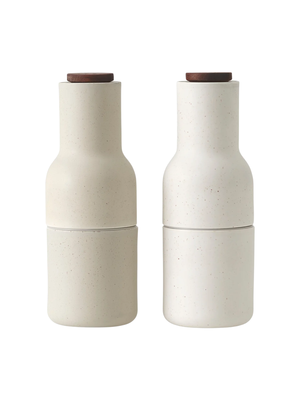 A pair of Bottle Grinders in a sand-coloured ceramic with a speckled finish and a dark wood lid, on a plain black background.