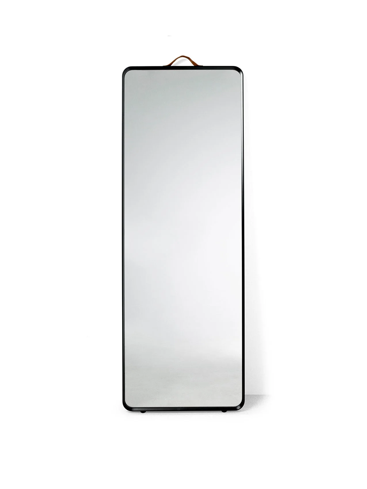 The Norm Floor Mirror in black, a full-length rectangular mirror with rounded corners, a thin frame and a leather strap.