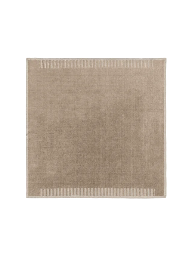 Top-down view of the square Duomo Rug in Limestone Beige. It has a decorative border with vertical stripes and fringed edges.