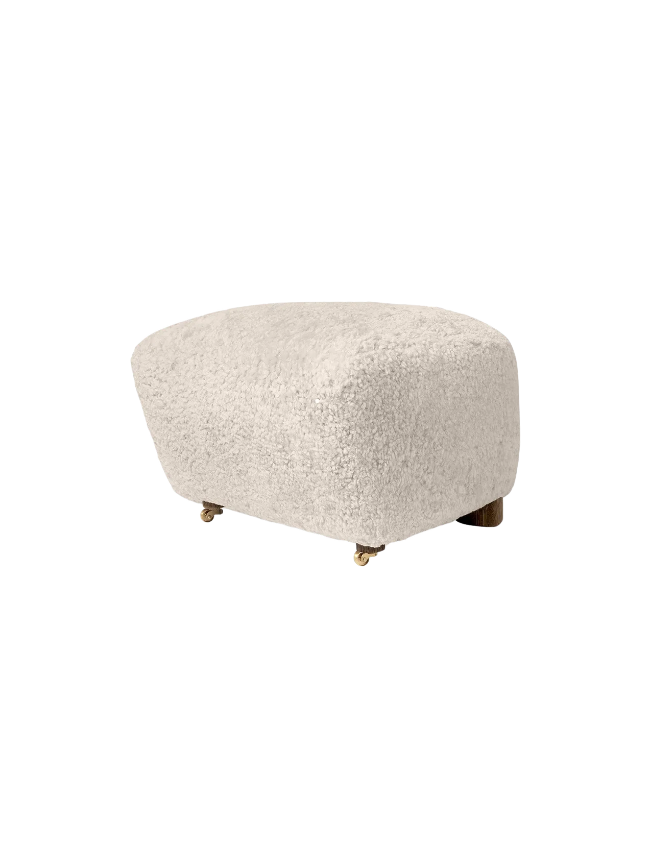 The Tired Man Ottoman, upholstered in plush Moonlight sheepskin with dark stained oak legs and small brass front wheels.