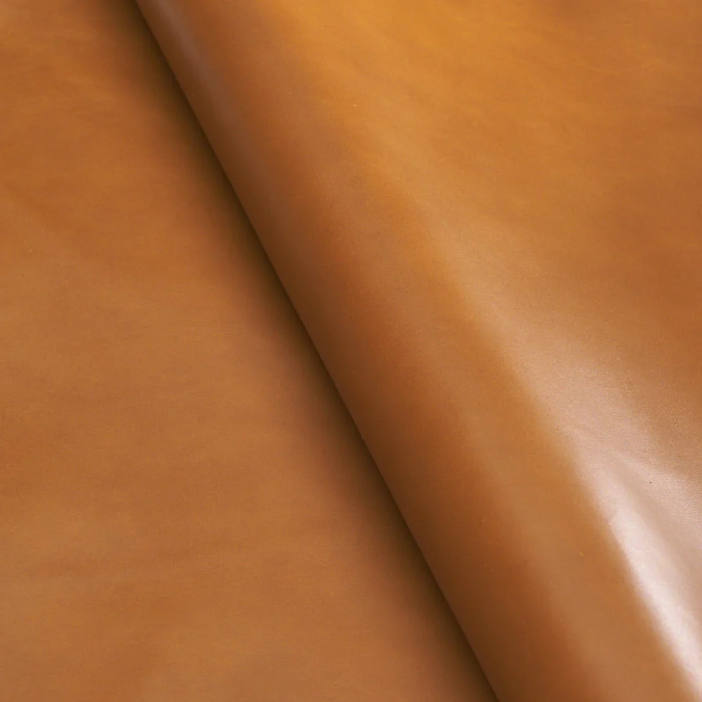 Rolled smooth tan leather hide with warm caramel color and subtle sheen, showing grain-free surface and soft drape