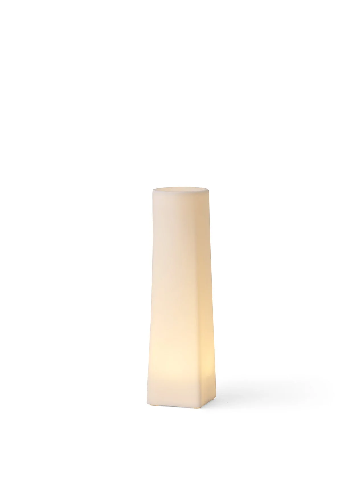 A single, tall Ignus Flameless Candle, lit up to cast a warm glow. It has a square base and is shown on a white background.