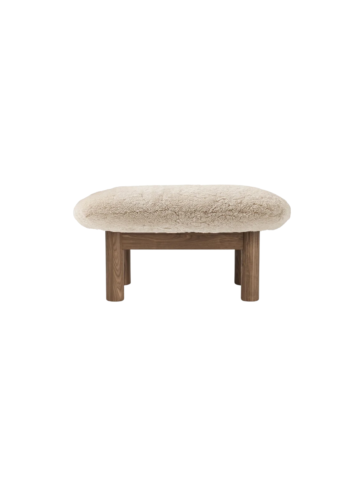 Front view of the Brasilia Ottoman, Sheepskin, featuring a plush, off-white cushion and four robust, cylindrical wooden legs.
