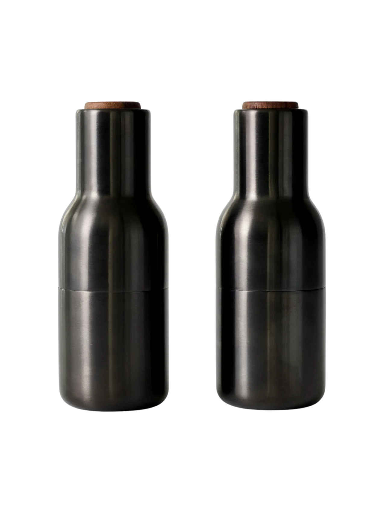 A front view of two Bottle Grinders made from bronzed brass with walnut lids, set against a black background.