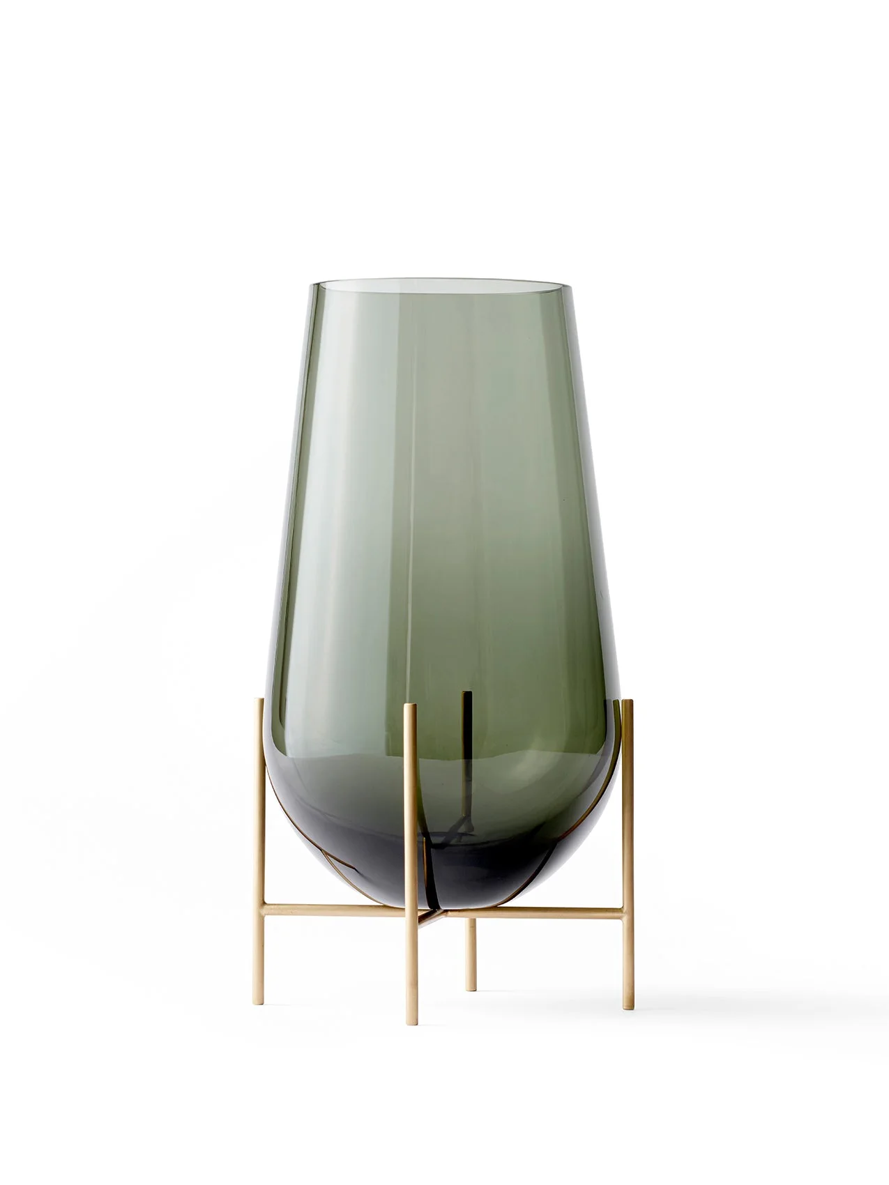 Echasse Vase M, a teardrop-shaped, smoked green glass vase on a slender, minimalist four-legged brass stand.