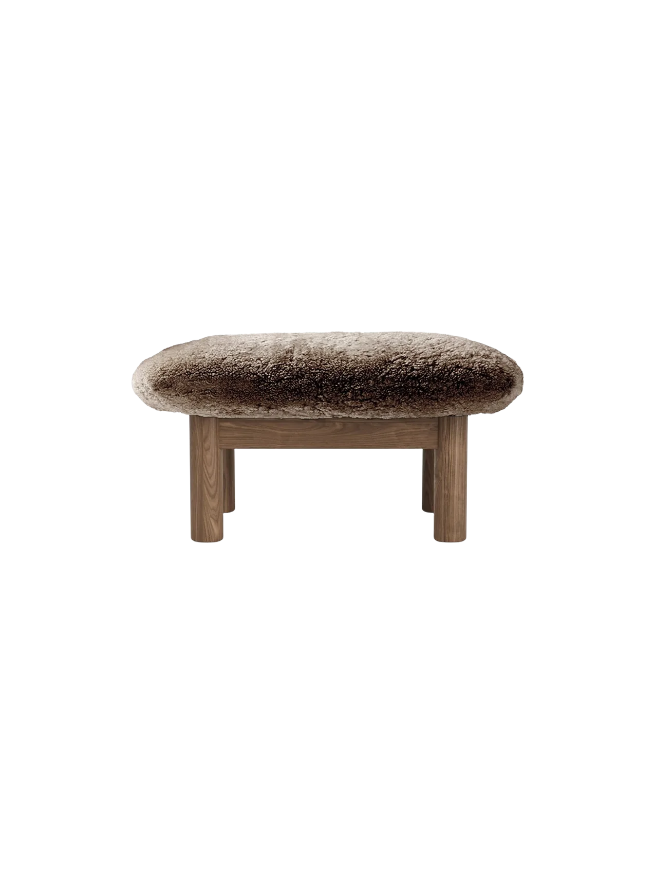 A front view of the Brasilia Ottoman, featuring a plush, brown sheepskin top and four robust, light-toned wooden legs.