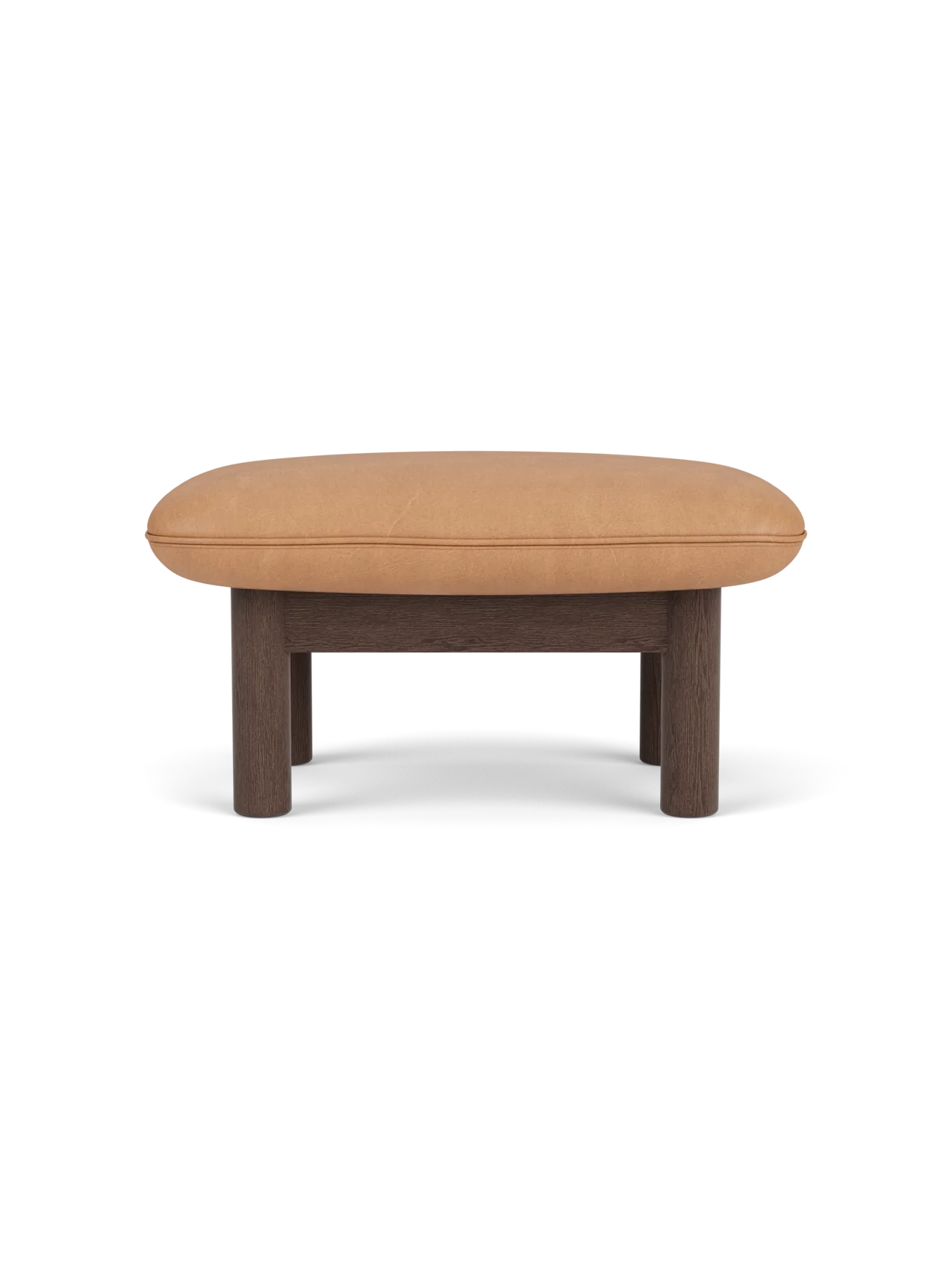 A side view of the Brasilia Ottoman, with a dark stained oak frame, four cylindrical legs, and plush camel leather seat.