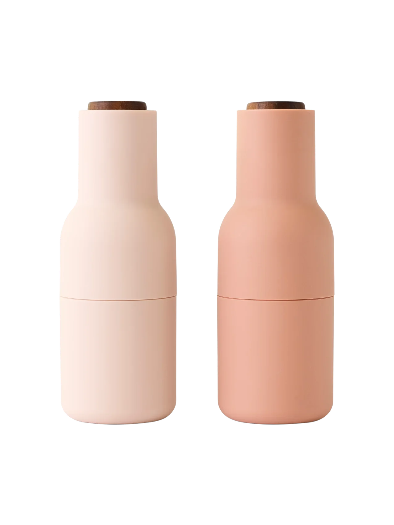 Front view of two Audo Bottle Grinders. One is a light nude pink and the other a darker blush nude, both with dark wood tops.