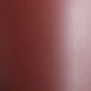 A close-up of a texture swatch in a burned red colour. The material has a smooth surface with a subtle sheen.