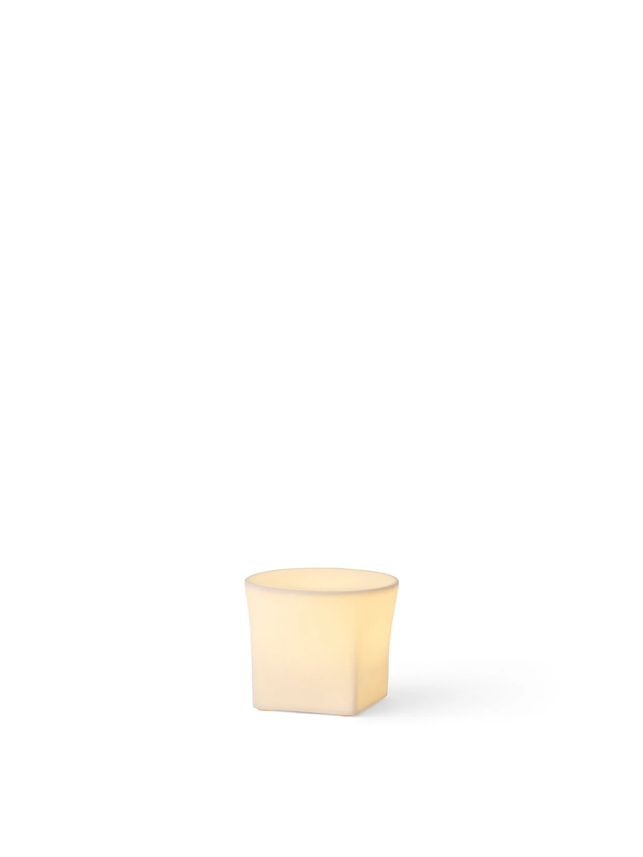 The small, square-shaped Ignus Flameless Candle (H8) made of bone china, glowing with a warm light on a white background.