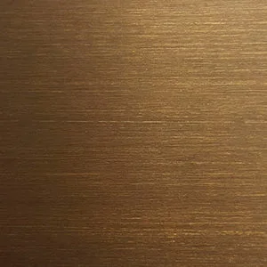 Close-up of a brushed brass surface, showing a textured finish with horizontal lines and a warm golden colour.